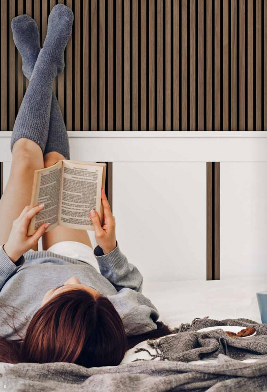 Frau im Bett, hält ihre Füsse an die Wand